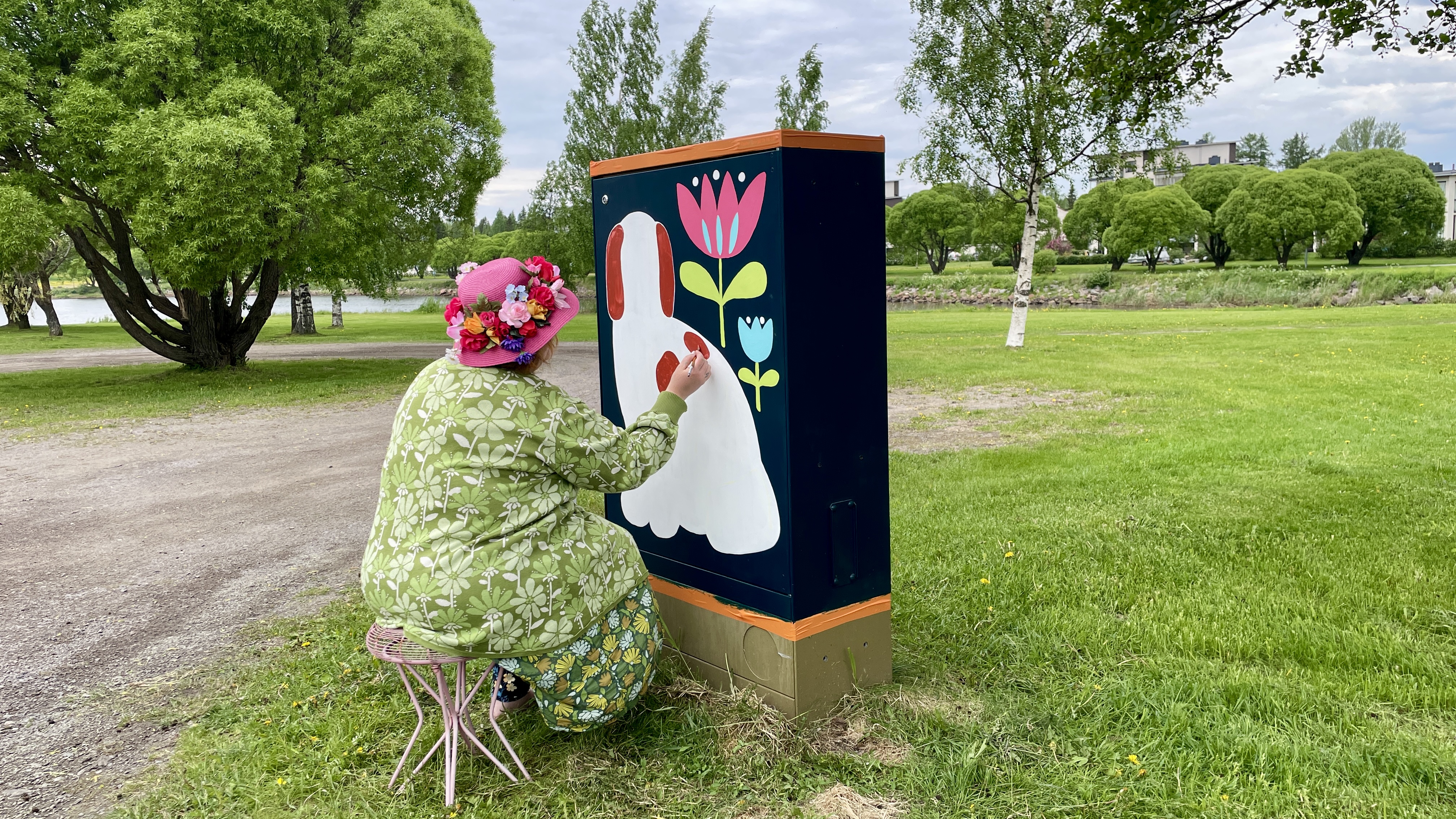 Taiteilija Milka Metsäpolku maalaamassa sähkökaappeja