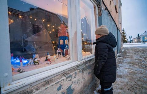 Lapsi tutkimassa joulukalenteri-ikkunaa.
