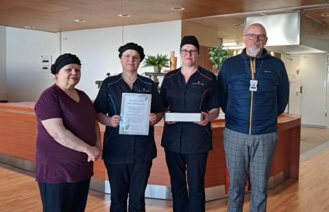 Kuvassa neljä henkilöä seisoo rivissä.