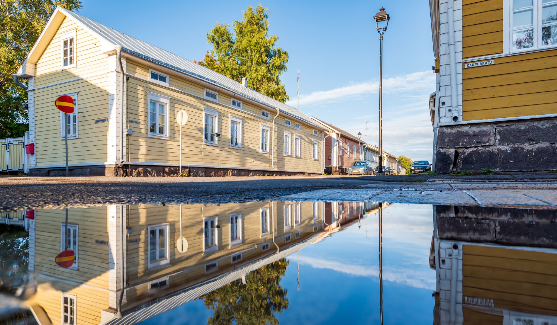 The wooden house and its reflection in the water on the street in old town Raahe.