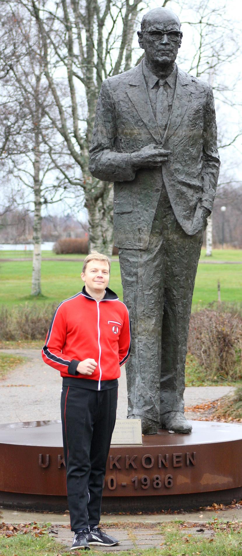 Hannu poses in Rautaruukki’s red tracksuit by the statue of Kekkonen.